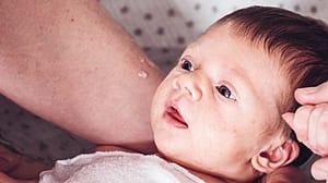 Baby wird in Armen gehalten