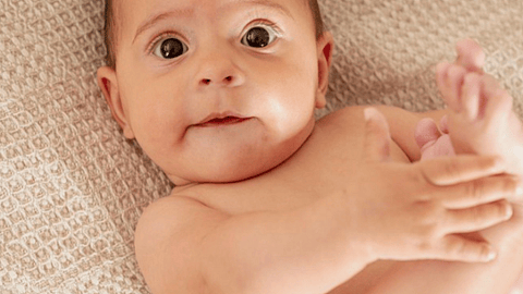 bebé sujetándose un pie