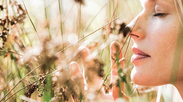 Vrouw ruikt aan een bloem
