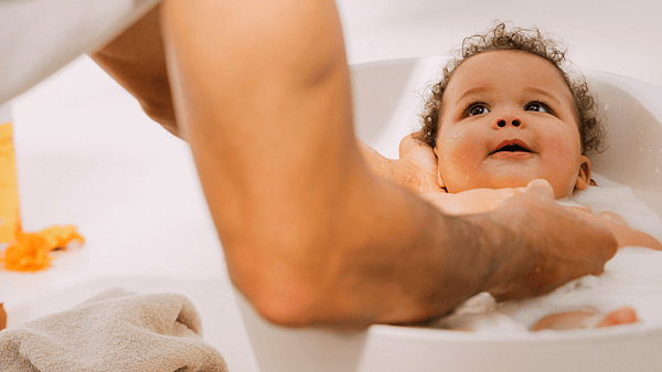 Mujer bañando a un bebé en una bañera