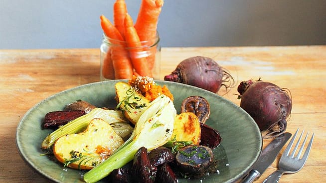 Auf einem Tisch steht das fertige Gericht mit Hummus, Fenchel und anderem Gemuese