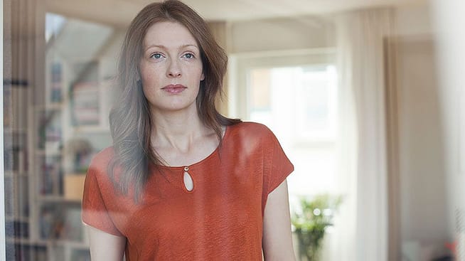 Woman looks through window