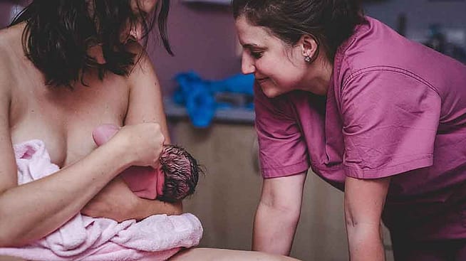 Ostetrica con madre che allatta.