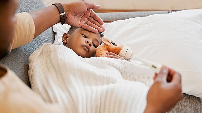 Kleiner Junge liegt krank im Bett