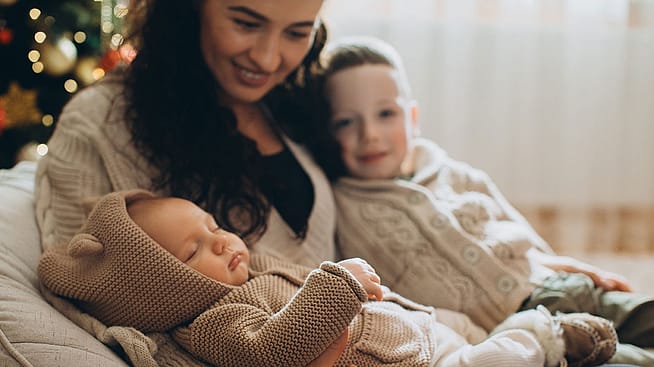 Mutter mit Kindern vor dem Baum