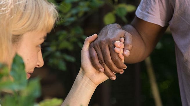 Frau haelt die Hand eines Mannes