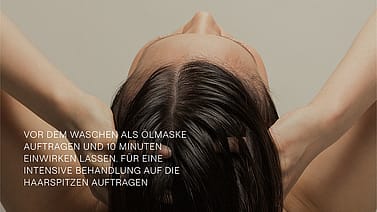 Frau von hinten massiert sich die Kopfhaut