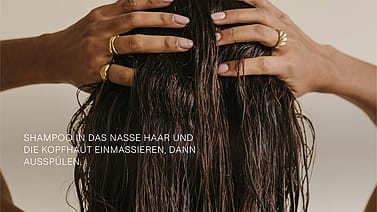 Frau von hinten am Haare waschen