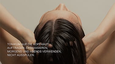 Frau von hinten massiert sich die Kopfhaut