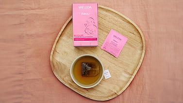 Tasse mit Stilltee, Verpackung und Beutel auf einem Tablett