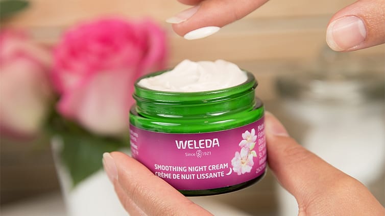 hand scooping weleda smoothing night cream from jar