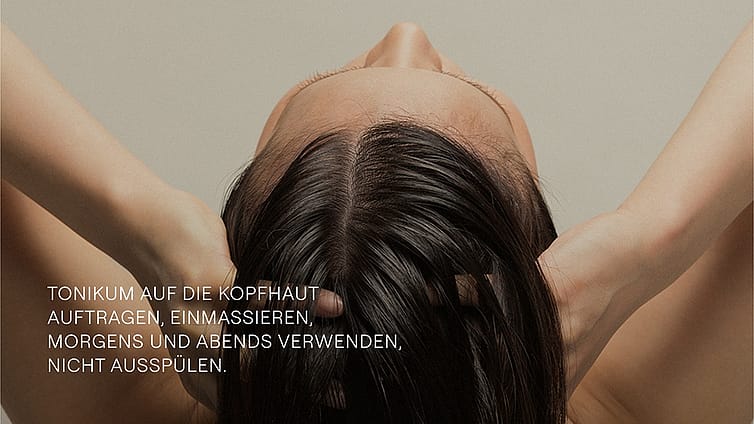 Frau von hinten massiert sich die Kopfhaut