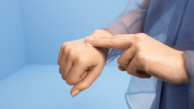 Mani che massaggiano il prodotto sulla pelle