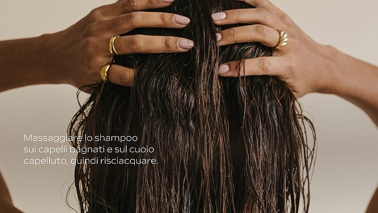 Mani che applicano shampoo sui capelli umidi