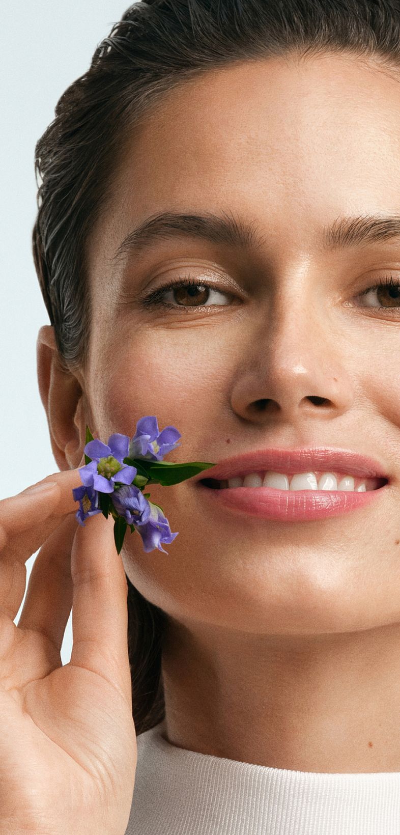Frau mit Blumenzweig am Mund