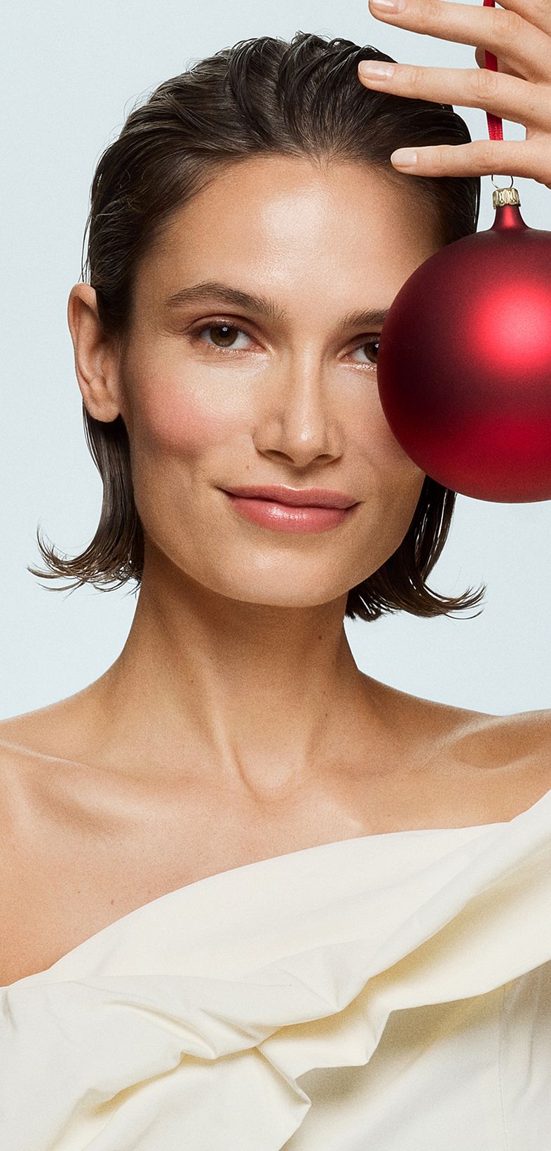 Femme avec une boule de Noël rouge