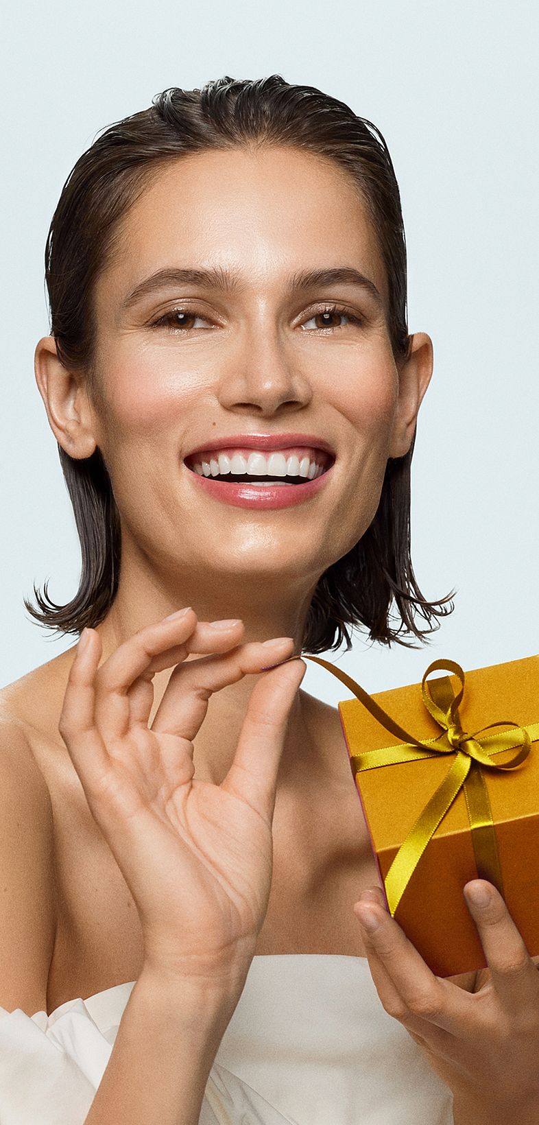 Lächelnde Frau mit goldenem Geschenk