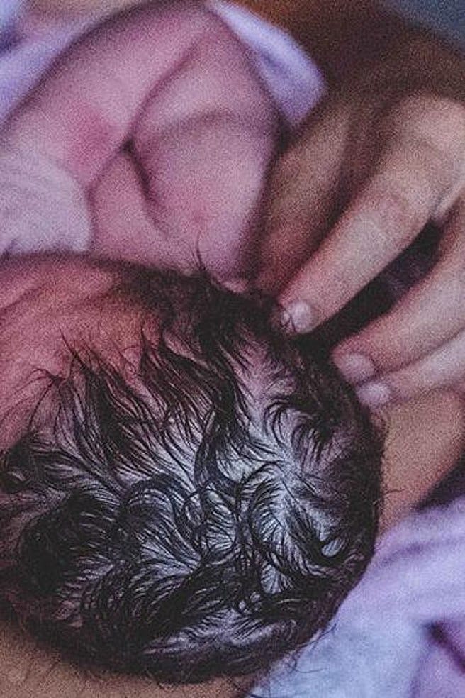 Una donna tiene in braccio un neonato dopo la nascita.