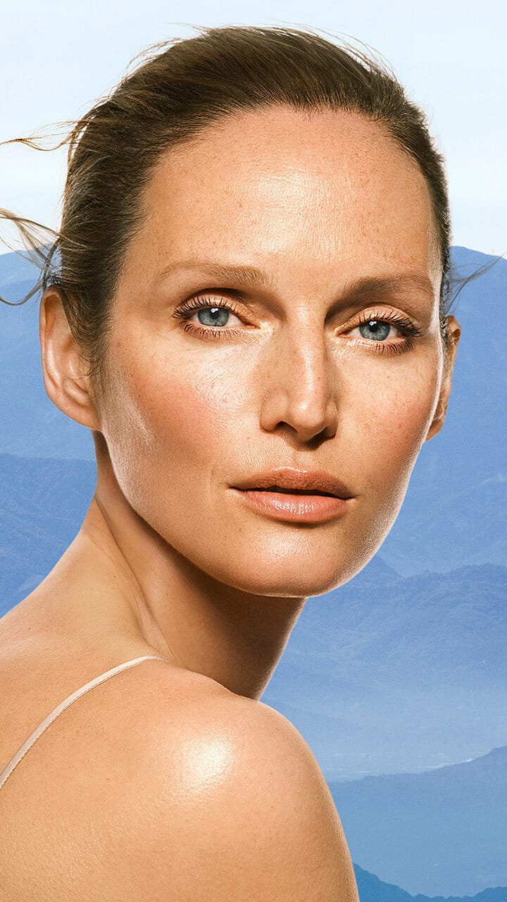 Portrait einer Frau mit blauen Bergen im Hintergrund