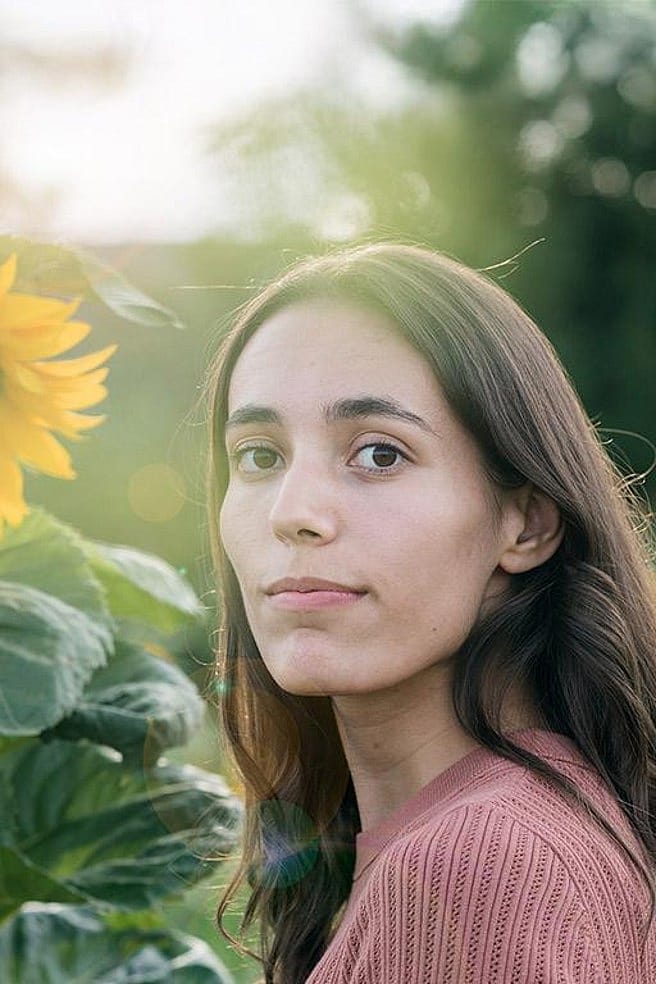Frau in einem Sonnenblumenfeld an einem sonnigen Tag