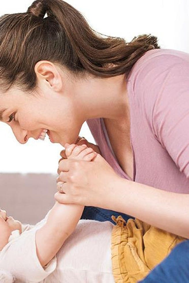 Frau lacht dem Baby zu