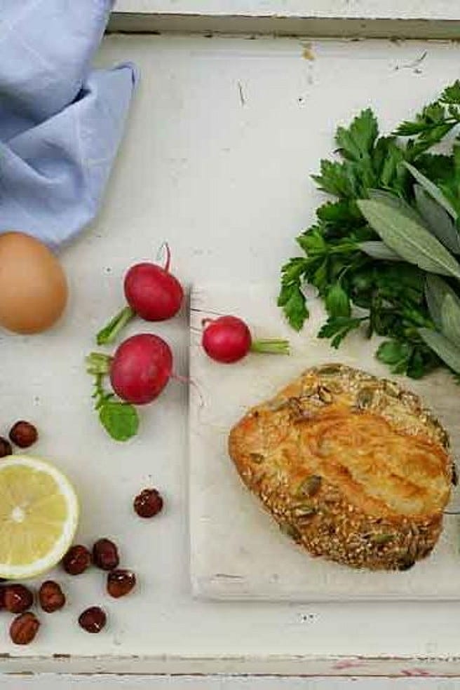 Auf einem Tablett liegen ein Broetchen, ein Ei, Kohlrabi und Kraeuter als Zutaten fuer den Burger
