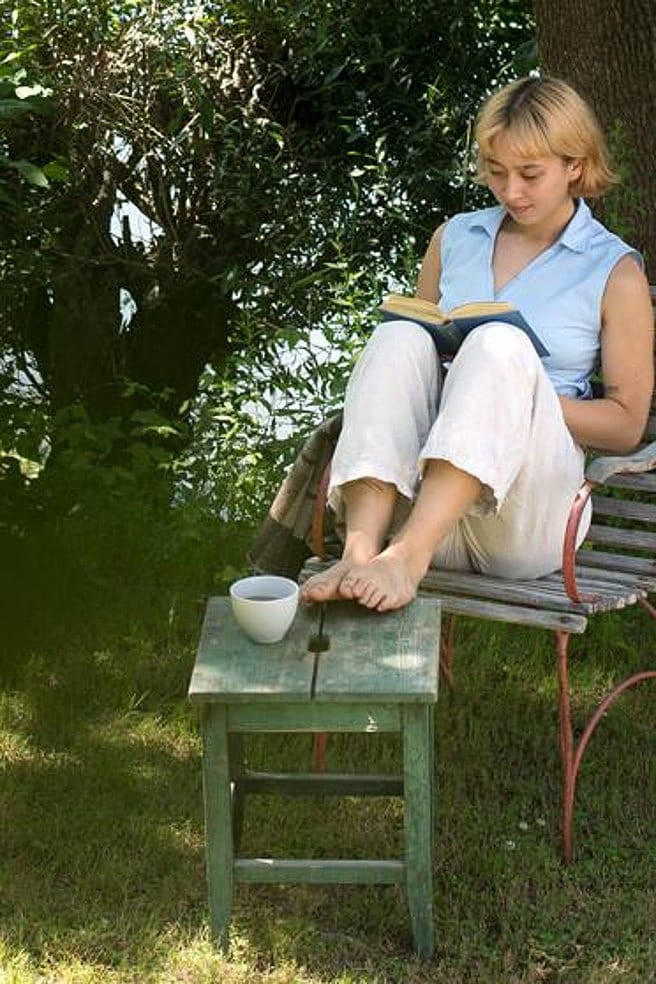 Frau sitzt entspannt im Garten