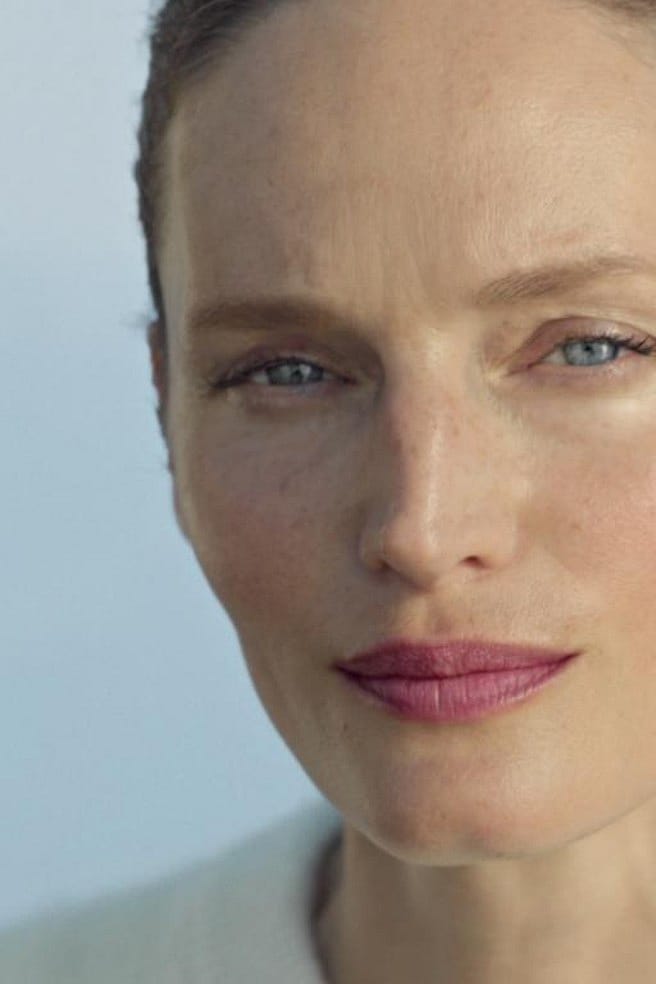 Vrouw smeert crème op haar wang