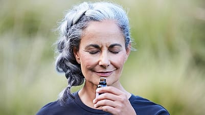 äldre kvinna luktar på lavendelblomma