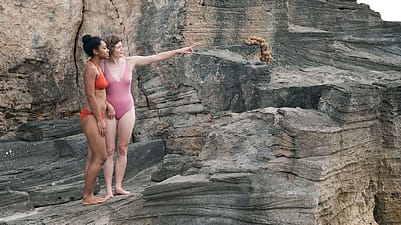 2 Frauen in Badekleider auf einem Felsen