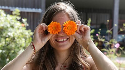 femme avec fleurs de calendula sur les yeux