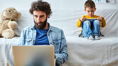 Père et fils devant des ordinateurs portables