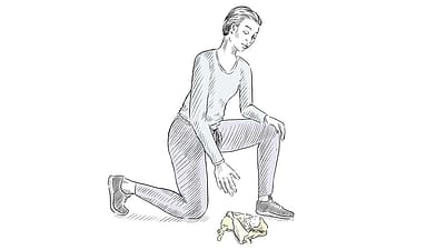 Donna piegata sulle ginocchia raccoglie oggetto da terra