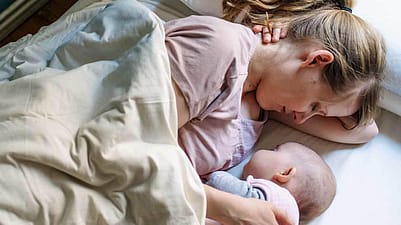 Mamma e bambino riposano nel letto sotto le lenzuola