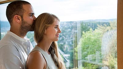 pareja abrazada mientras mira por la ventana