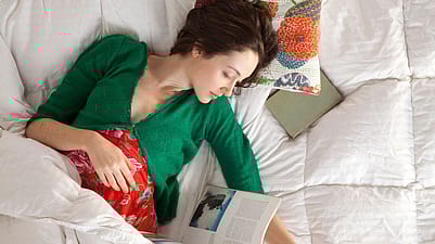 mujer embarazada leyendo en la cama