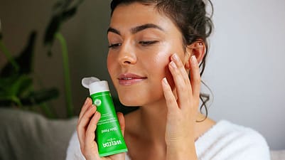 Frau trägt Weleda Skin Food als Highlighter auf Wangenknochen auf