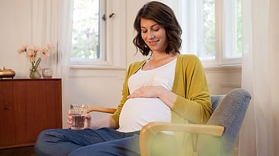 Frau betrachtet ihren Bauch