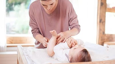 madre cambiando pañal a bebe