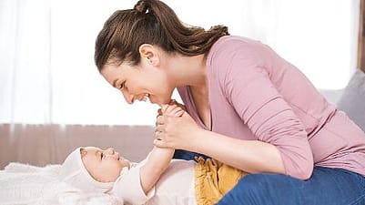 Frau lacht dem Baby zu