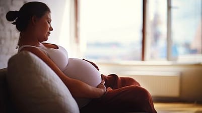 Schwangere legt Hand auf Bauch