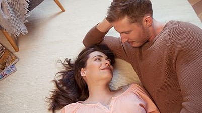 Glückliches Paar auf dem Teppichboden liegend