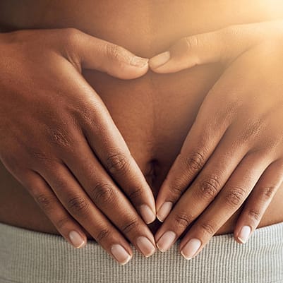 Kvinna med händerna på magen