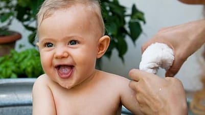 madre bañando a un bebé con una esponja