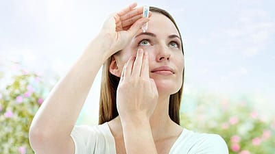 Femme s'appliquant des goutes dans les yeux