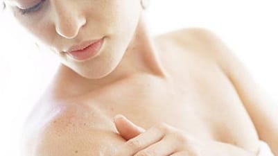 femme qui s'applique de la crème sur le bras