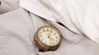 réveil posé dans un lit