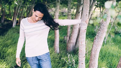 femme se tenant à un arbre