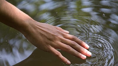 mano tocando agua
