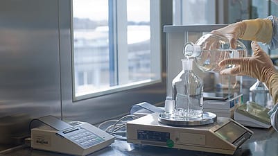 due mani che traversano liquido in due ampolle